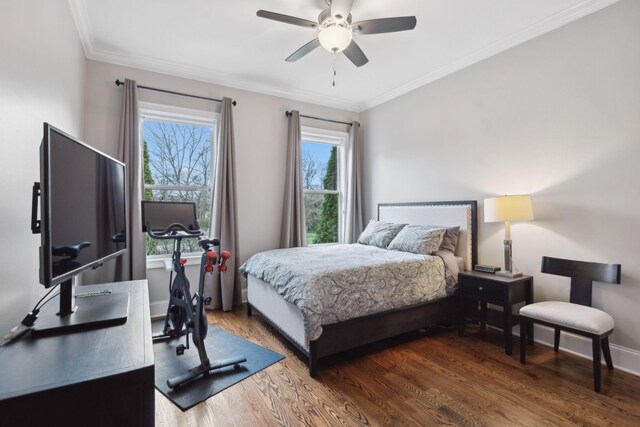 bedroom with baseboards, multiple windows, wood finished floors, and crown molding