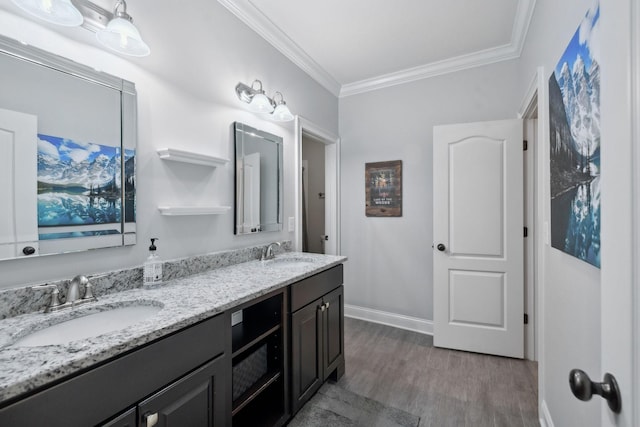 bathroom featuring ornamental molding, double vanity, a sink, and wood finished floors