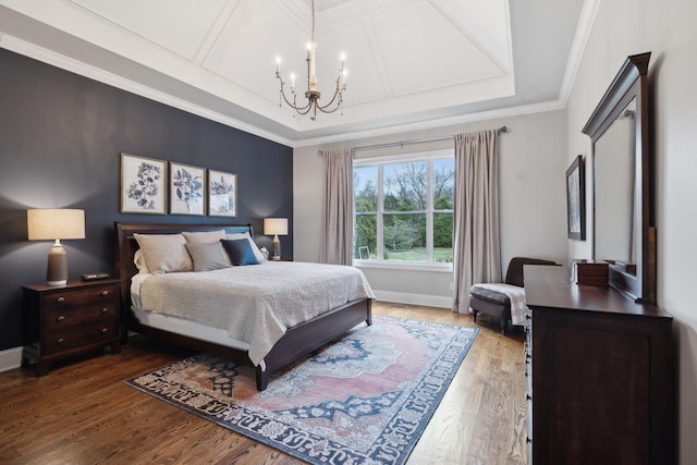 bedroom with baseboards, coffered ceiling, wood finished floors, crown molding, and a chandelier