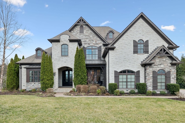 french country home with brick siding and a front lawn