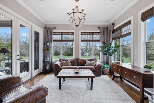 sunroom with plenty of natural light and a notable chandelier