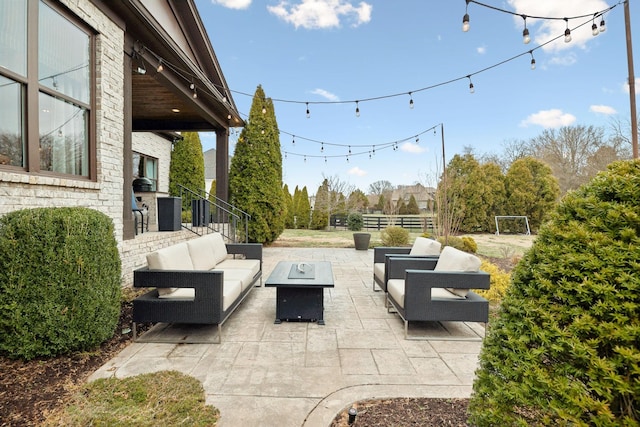 view of patio / terrace with fence and an outdoor living space with a fire pit