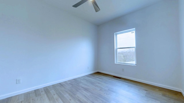 unfurnished room featuring ceiling fan, wood finished floors, visible vents, and baseboards