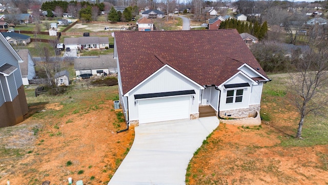 view of front facade featuring roof with shingles, an attached garage, concrete driveway, crawl space, and a residential view