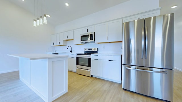 kitchen with light countertops, white cabinets, appliances with stainless steel finishes, and a sink