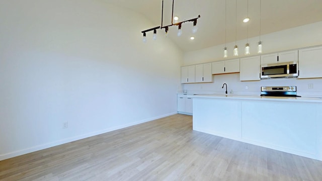 kitchen featuring light countertops, light wood-style floors, appliances with stainless steel finishes, and a sink