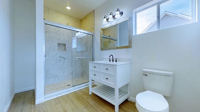 full bath with toilet, wood finished floors, a stall shower, and baseboards