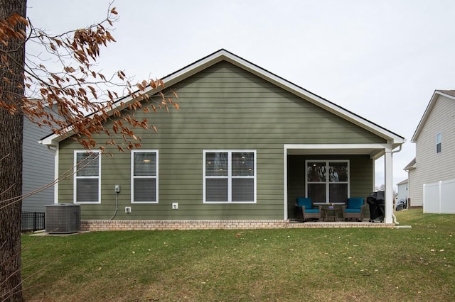 back of property with cooling unit and a lawn