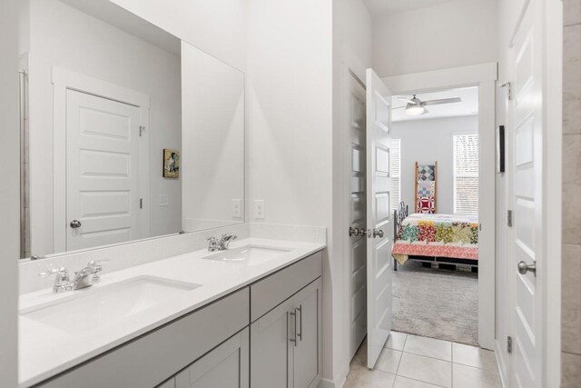 ensuite bathroom featuring tile patterned flooring, ensuite bath, ceiling fan, and a sink