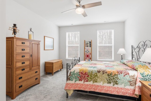 bedroom featuring light carpet, baseboards, and a ceiling fan