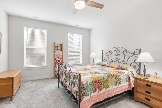 carpeted bedroom featuring visible vents, baseboards, and a ceiling fan