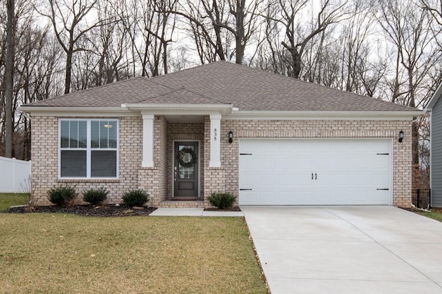 view of front of house with a garage, roof with shingles, fence, a front lawn, and brick siding