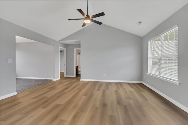 unfurnished room featuring visible vents, baseboards, a ceiling fan, wood finished floors, and vaulted ceiling