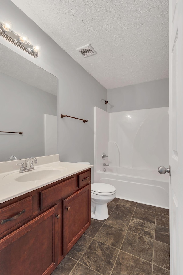 full bathroom featuring a textured ceiling, bathtub / shower combination, toilet, visible vents, and vanity