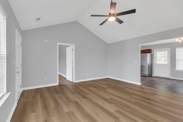 spare room with ceiling fan, baseboards, vaulted ceiling, and dark wood-type flooring