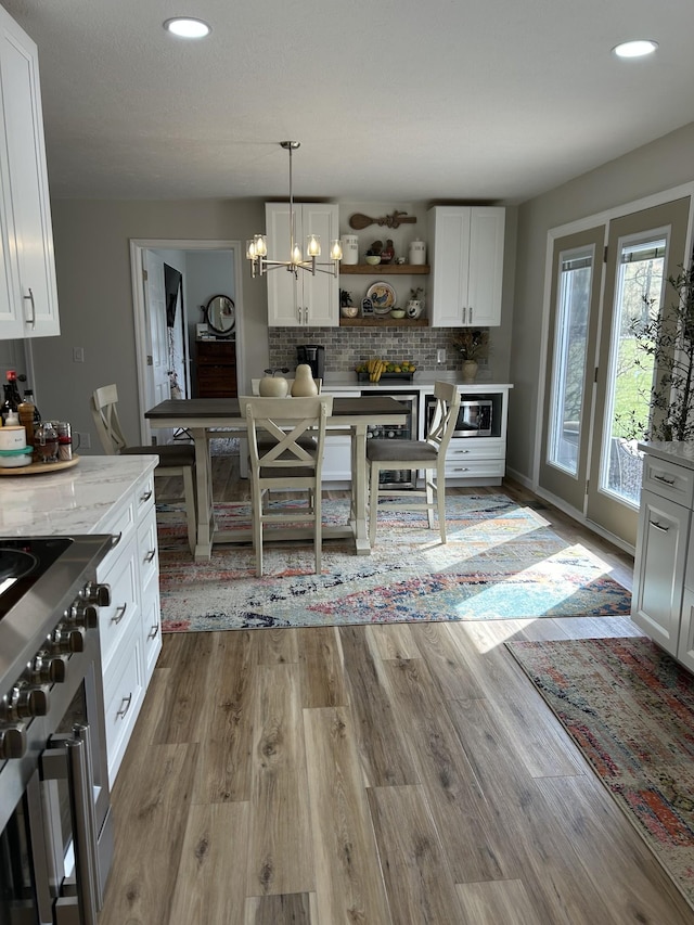 kitchen featuring open shelves, light wood-style floors, double oven range, and white cabinets