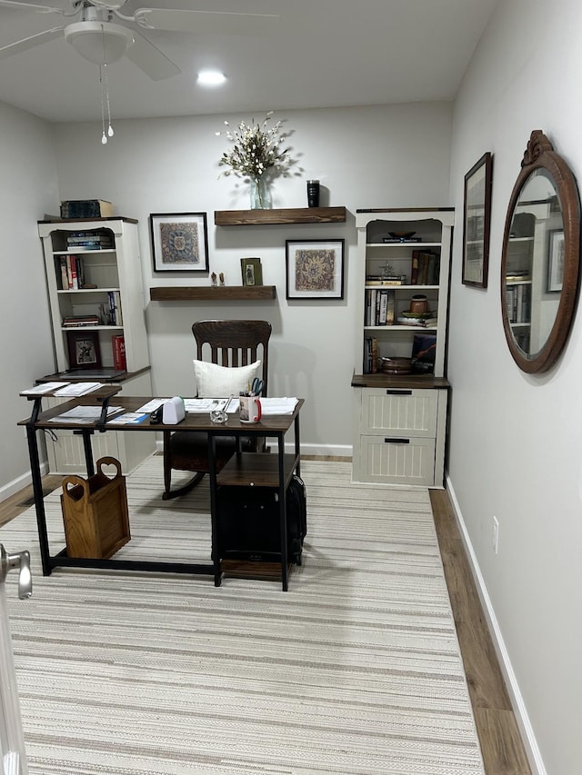 office space with a ceiling fan, baseboards, and wood finished floors