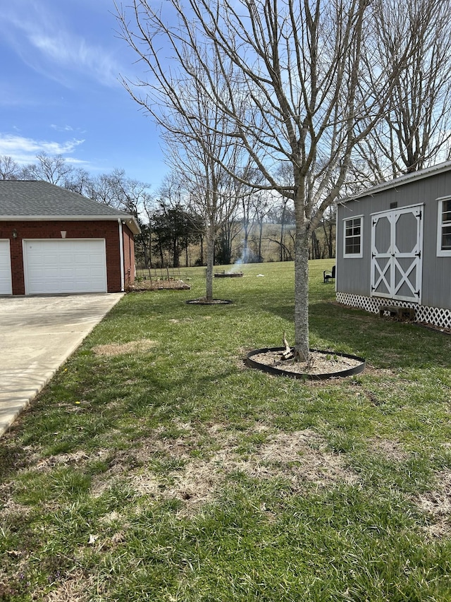 view of yard with a garage, an outbuilding, driveway, and a storage unit