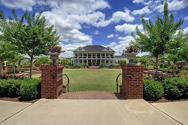 view of front facade featuring a front yard and a gate