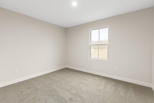 carpeted empty room featuring baseboards