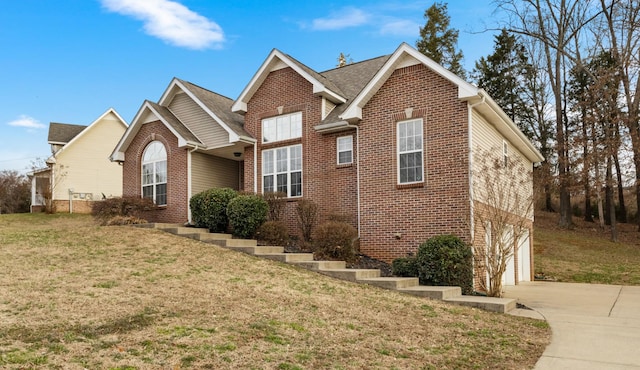 view of front facade with a garage, driveway, brick siding, and a front yard