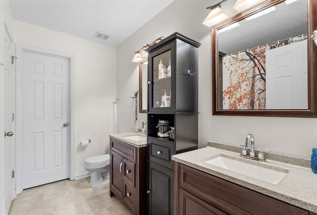 bathroom featuring two vanities, visible vents, a sink, and toilet