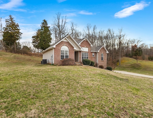 view of front of house with brick siding, a front yard, and central air condition unit