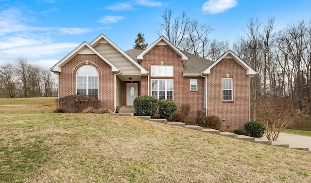 ranch-style house with brick siding, a front lawn, and a shingled roof