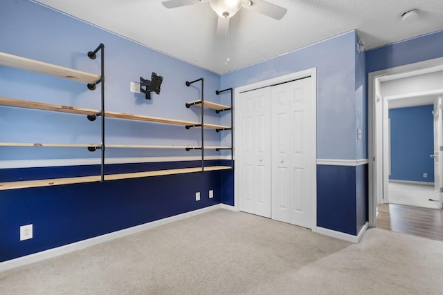 unfurnished bedroom with carpet floors, a textured ceiling, baseboards, and a closet