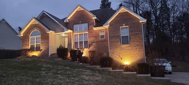 view of front of home with a front lawn and brick siding