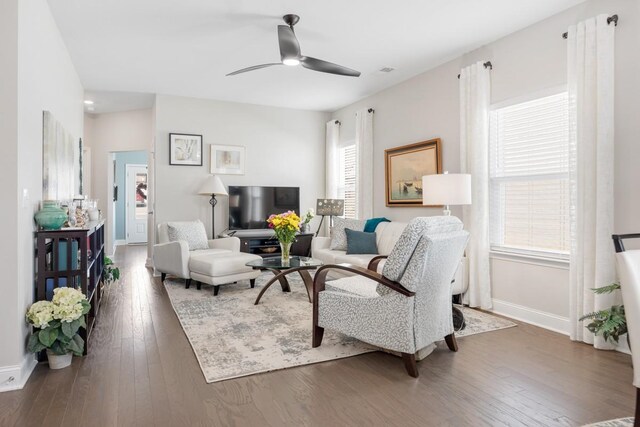 living room featuring hardwood / wood-style floors, a ceiling fan, and baseboards