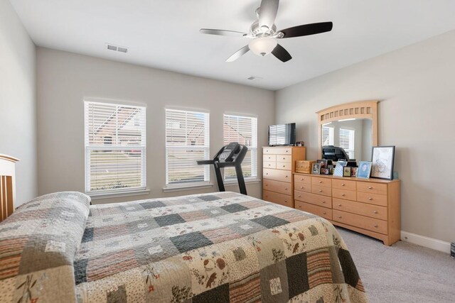 bedroom featuring light carpet, ceiling fan, visible vents, and baseboards