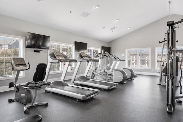 gym with vaulted ceiling, visible vents, a wealth of natural light, and baseboards