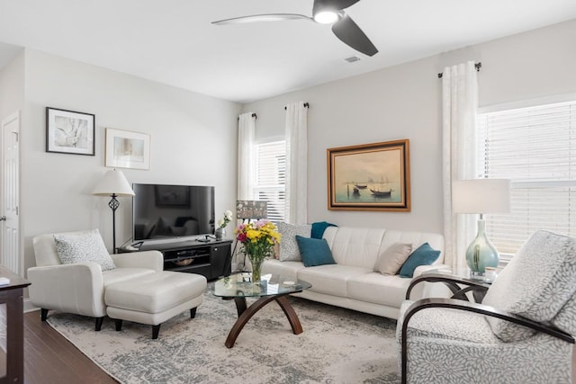 living area with a ceiling fan and wood finished floors