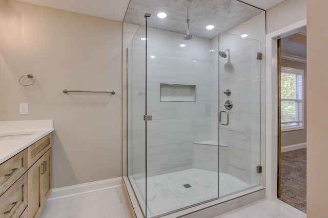 full bathroom featuring a stall shower, vanity, and baseboards