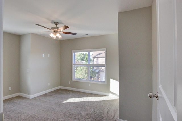 unfurnished room with a ceiling fan, light colored carpet, and baseboards