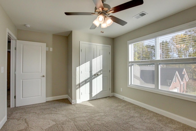 unfurnished bedroom featuring a closet, carpet flooring, visible vents, and baseboards