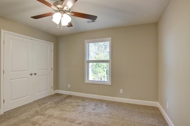 unfurnished bedroom with light colored carpet, a ceiling fan, baseboards, visible vents, and a closet