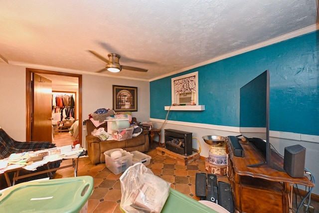 interior space featuring a textured ceiling, a ceiling fan, a wood stove, and crown molding