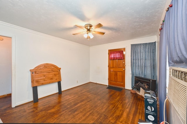 entrance foyer with ceiling fan, a textured ceiling, wood finished floors, baseboards, and crown molding