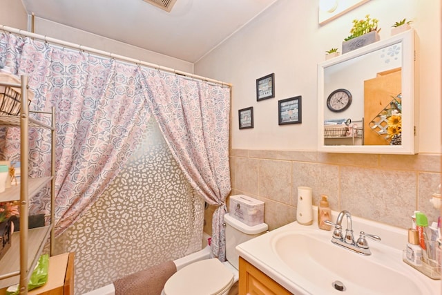 full bath with shower / bath combo, tile walls, toilet, and vanity