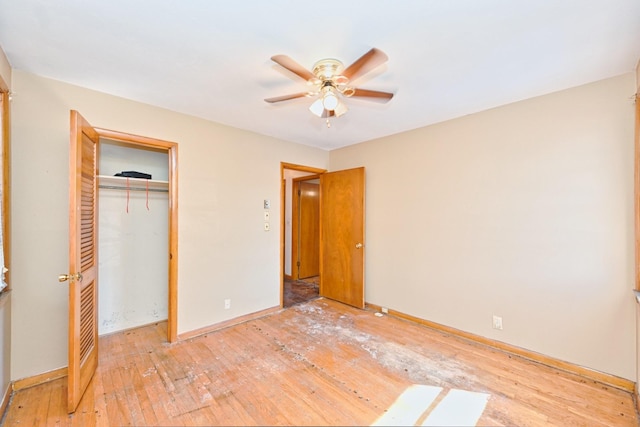 unfurnished bedroom featuring wood-type flooring, baseboards, ceiling fan, and a closet