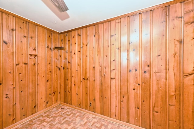 unfurnished room with wooden walls and baseboards