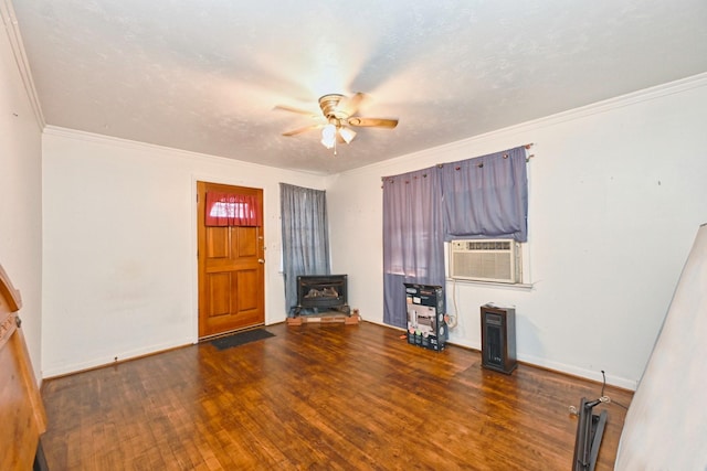 unfurnished living room with hardwood / wood-style flooring, a ceiling fan, baseboards, a wood stove, and crown molding