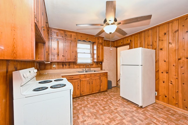 kitchen with white appliances, brown cabinets, light countertops, wood walls, and a sink