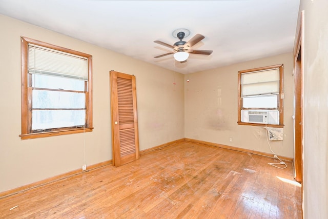 spare room featuring cooling unit, wood-type flooring, ceiling fan, and baseboards