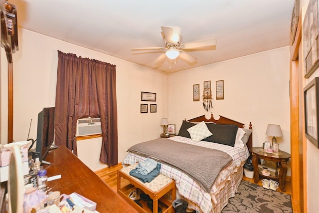 bedroom featuring ceiling fan, cooling unit, and wood finished floors