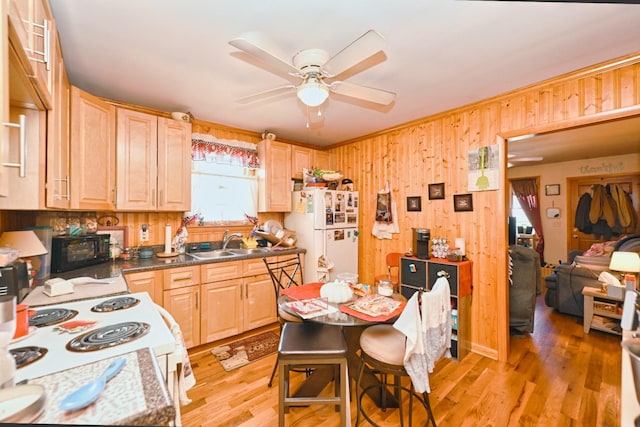 kitchen with a sink, white appliances, light wood-type flooring, and light brown cabinets