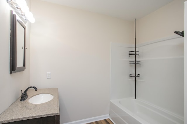 full bathroom featuring bathtub / shower combination, wood finished floors, vanity, and baseboards