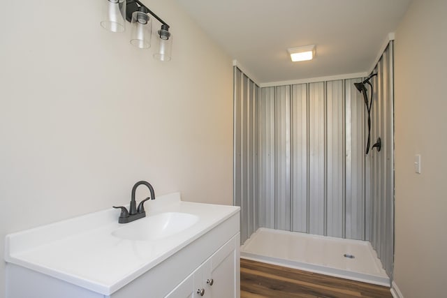 full bath featuring a shower, vanity, and wood finished floors